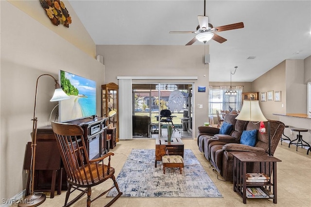 living room featuring ceiling fan with notable chandelier, lofted ceiling, and light tile patterned flooring