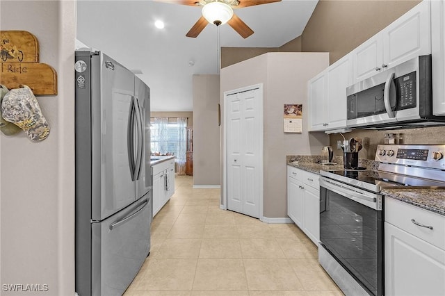 kitchen featuring white cabinets, ceiling fan, dark stone countertops, light tile patterned floors, and stainless steel appliances