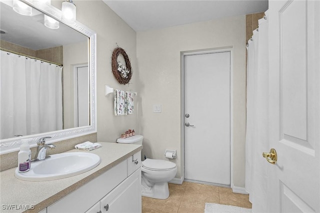 bathroom with tile patterned flooring, vanity, and toilet