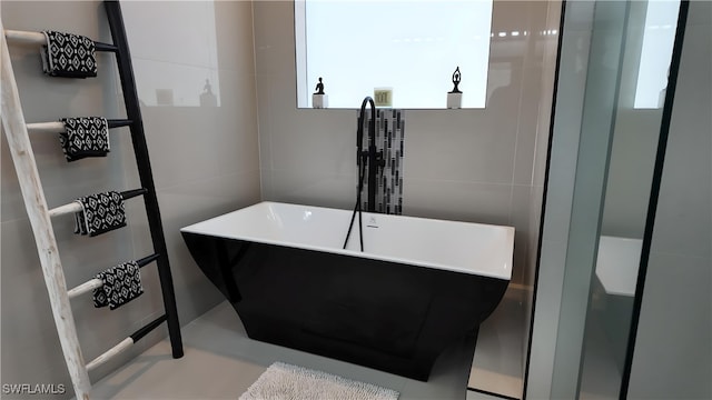 bathroom featuring a tub and tile walls