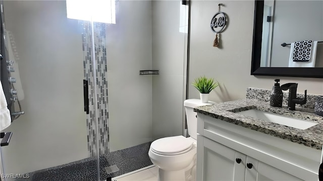 bathroom featuring tile patterned floors, vanity, toilet, and a shower with shower door