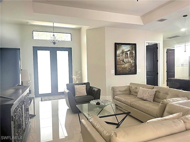 living room with plenty of natural light, light tile patterned flooring, and a notable chandelier