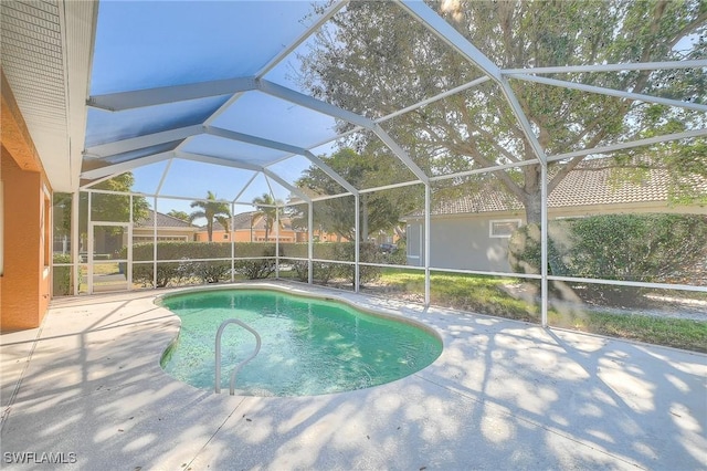 view of pool featuring glass enclosure and a patio area