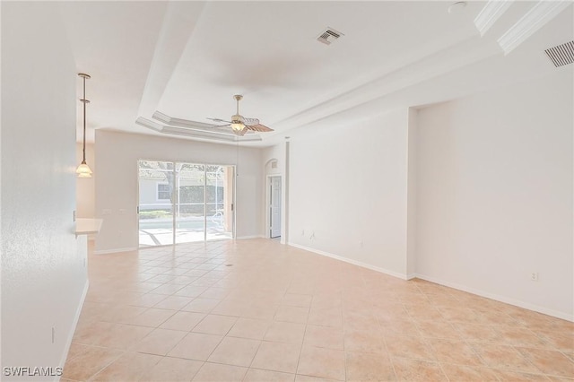 tiled spare room featuring a raised ceiling and ceiling fan