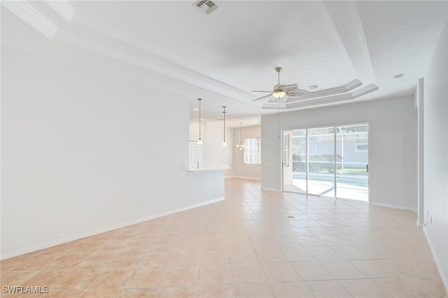 empty room featuring a raised ceiling, ceiling fan, and light tile patterned floors