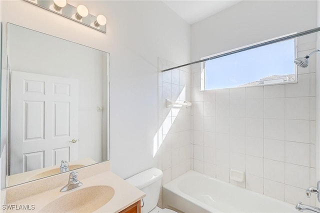 full bathroom with toilet, vanity, and tiled shower / bath