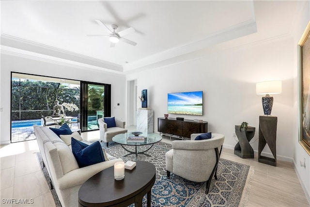 living room with light hardwood / wood-style flooring, a raised ceiling, ceiling fan, and crown molding