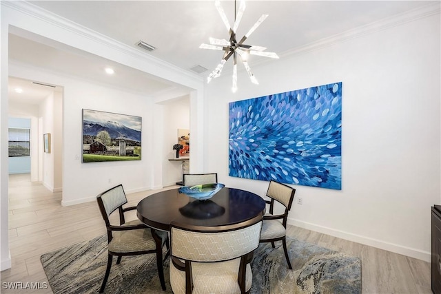 dining area featuring ornamental molding, light hardwood / wood-style floors, and a notable chandelier