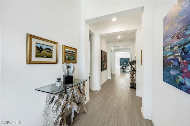 hall featuring light hardwood / wood-style floors and ornamental molding