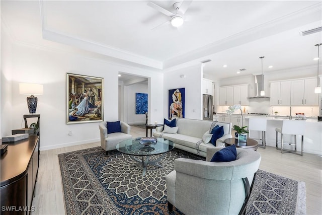 living room with ceiling fan, light hardwood / wood-style floors, and ornamental molding