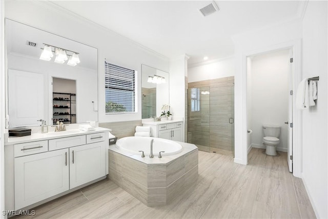 full bathroom featuring plus walk in shower, crown molding, wood-type flooring, toilet, and vanity