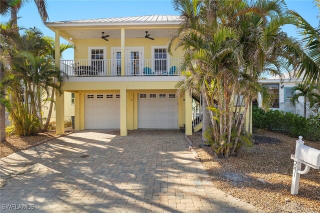 view of front facade with ceiling fan, french doors, and a garage