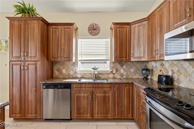 241 Pearl St, Fort Myers Beach, FL 33931 - kitchen with dark stone countertops, stainless steel appliances, brown cabinets, and a sink