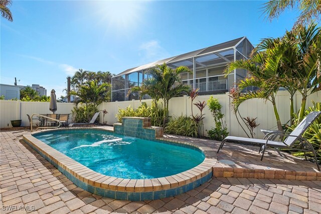 view of pool featuring glass enclosure and a patio area