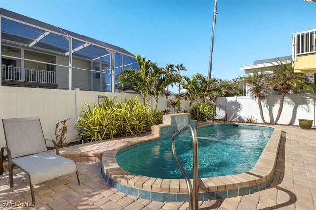 view of swimming pool featuring a patio and a lanai