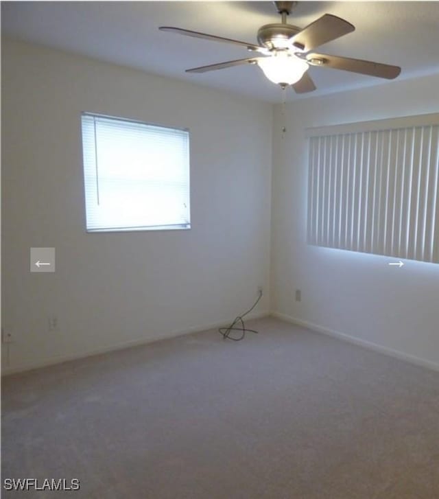 carpeted spare room with ceiling fan