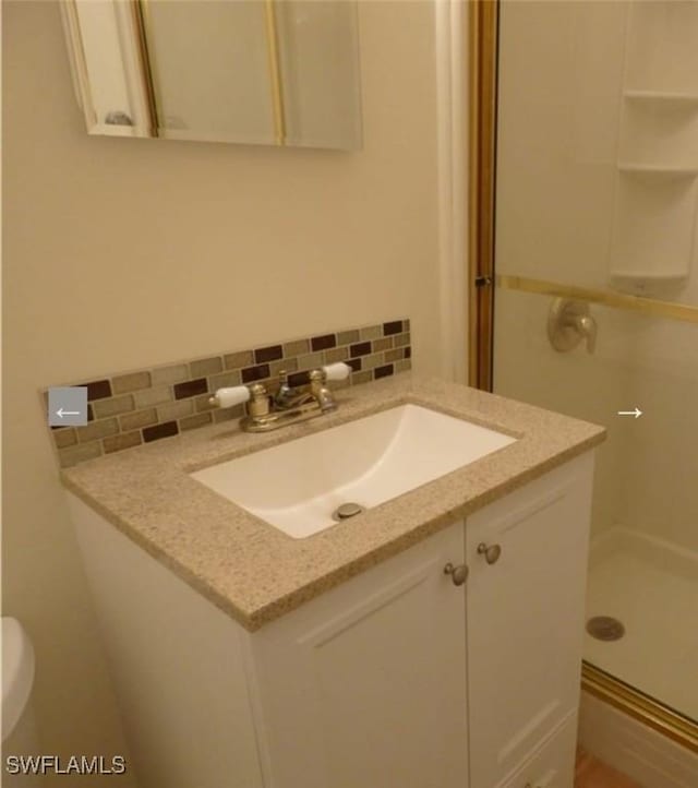 bathroom featuring decorative backsplash, vanity, and walk in shower