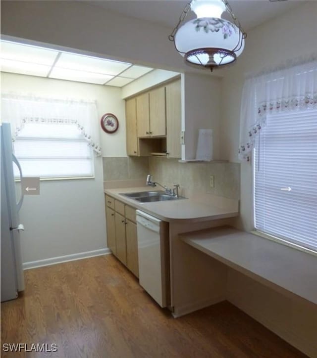 kitchen featuring dishwasher, sink, fridge, decorative backsplash, and light wood-type flooring