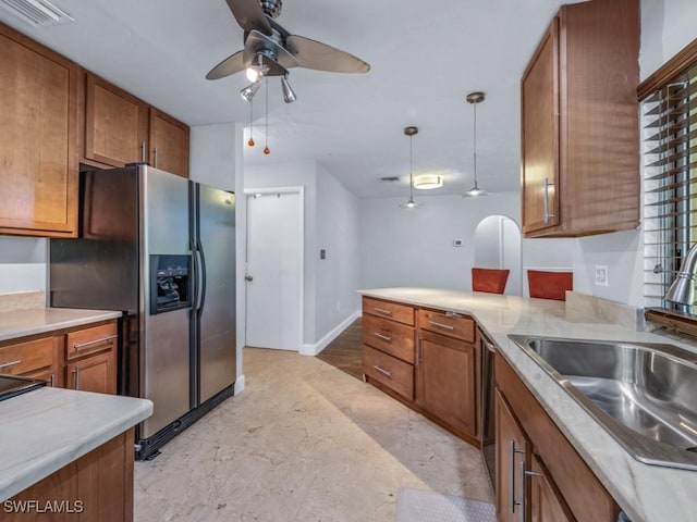 kitchen with pendant lighting, ceiling fan, sink, and stainless steel refrigerator with ice dispenser