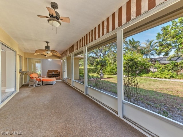 unfurnished sunroom with ceiling fan