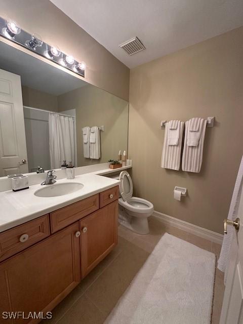 bathroom with tile patterned floors, vanity, a shower with shower curtain, and toilet