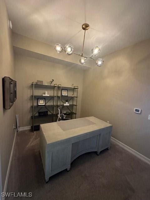 home office featuring an inviting chandelier and dark colored carpet