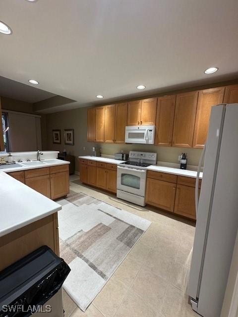 kitchen featuring sink, white appliances, and light tile patterned flooring