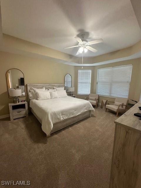 bedroom with ceiling fan and dark carpet