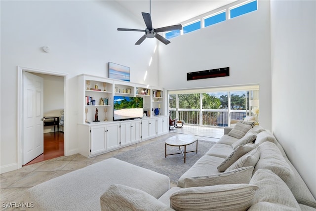 living room featuring ceiling fan, light tile patterned floors, and a high ceiling