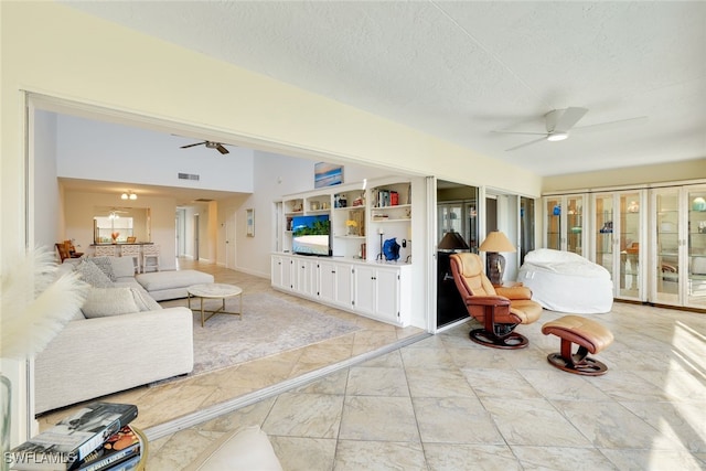 living room featuring ceiling fan and a textured ceiling