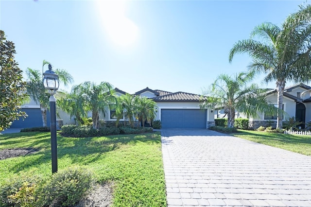 view of front of house with a garage, a front lawn, decorative driveway, and stucco siding