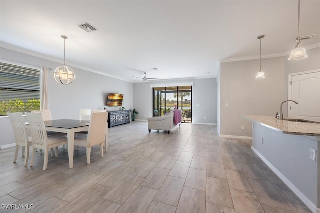 dining area with ornamental molding, visible vents, light wood finished floors, and baseboards