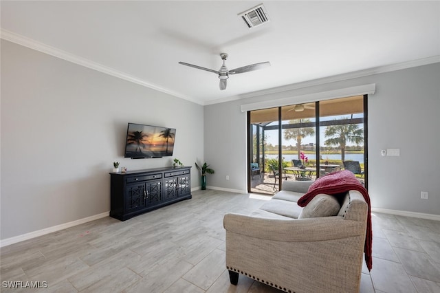 living area with baseboards, a ceiling fan, visible vents, and crown molding