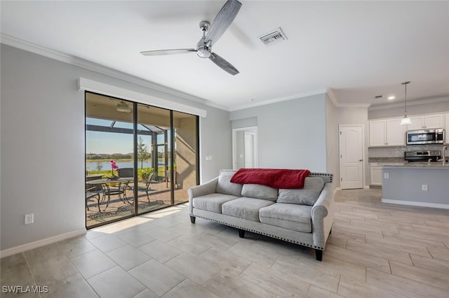 living room with visible vents, a water view, ornamental molding, ceiling fan, and baseboards