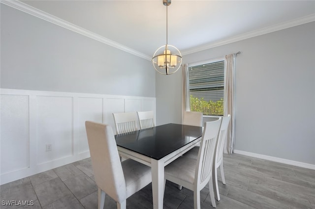 unfurnished dining area featuring a notable chandelier, a decorative wall, crown molding, and wainscoting