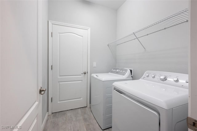 laundry area featuring laundry area, independent washer and dryer, and light wood finished floors