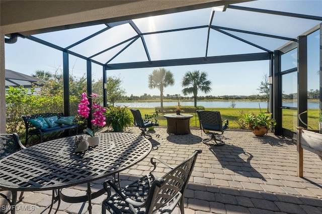 view of patio with a lanai and a water view