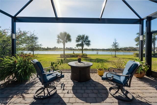 view of patio featuring glass enclosure and a water view