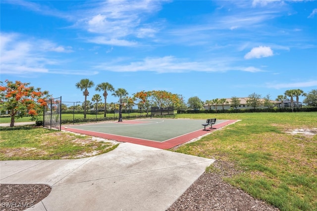 view of sport court with community basketball court, a lawn, and fence