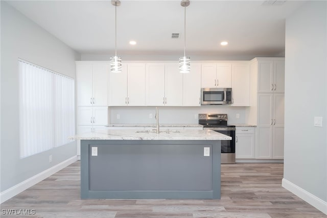 kitchen featuring a kitchen island with sink, white cabinets, hanging light fixtures, sink, and appliances with stainless steel finishes