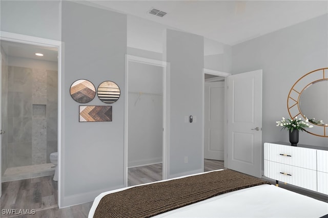 bedroom with a walk in closet, ensuite bathroom, a closet, and light hardwood / wood-style floors