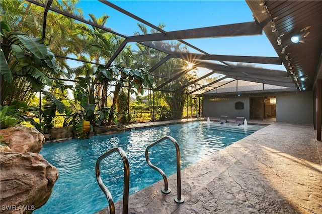 view of pool with a patio, pool water feature, and a lanai