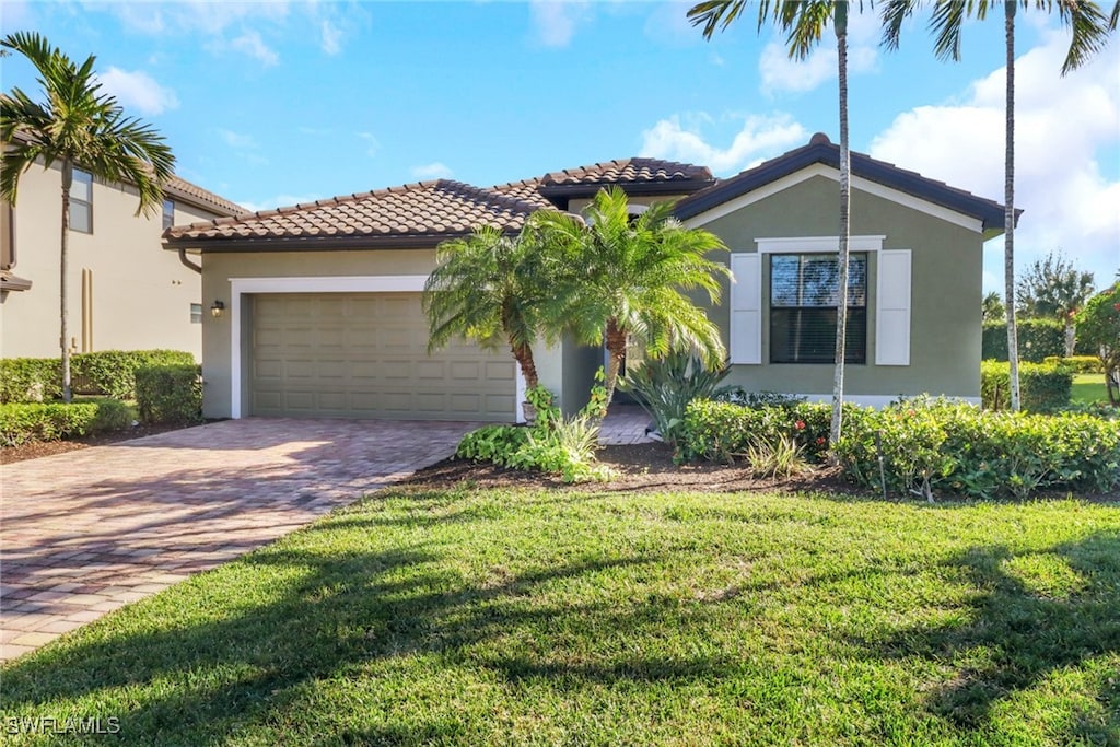 mediterranean / spanish-style house featuring a front yard and a garage