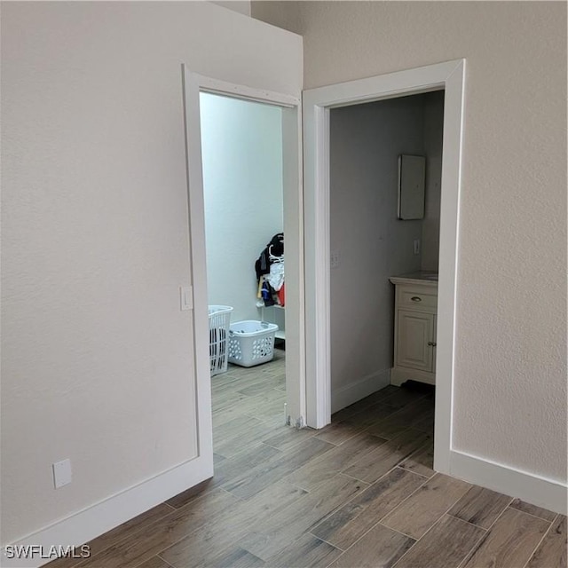 corridor featuring baseboards and wood tiled floor