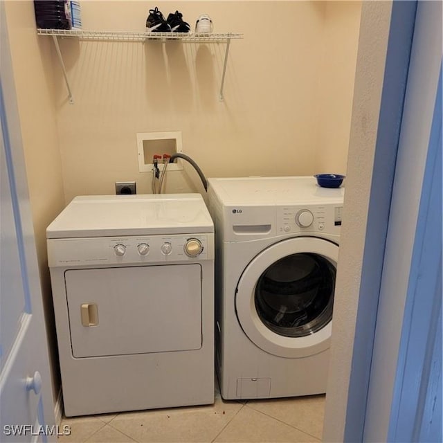 laundry room with light tile patterned flooring and washer and dryer