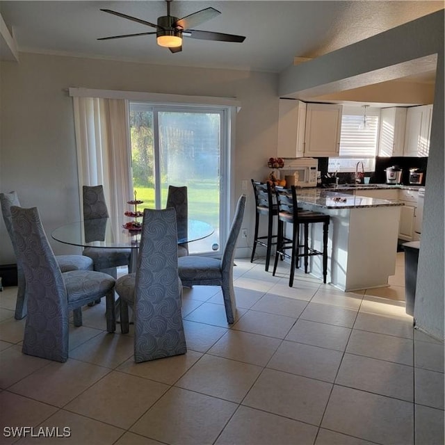 dining space with ceiling fan, plenty of natural light, and light tile patterned floors