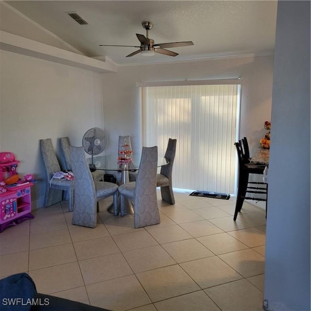 dining area with ornamental molding, ceiling fan, lofted ceiling, and light tile patterned flooring