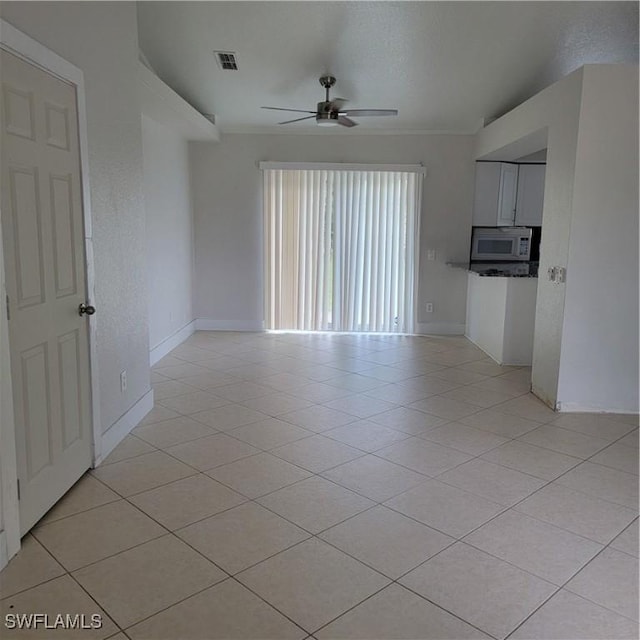 unfurnished living room featuring ceiling fan and light tile patterned flooring