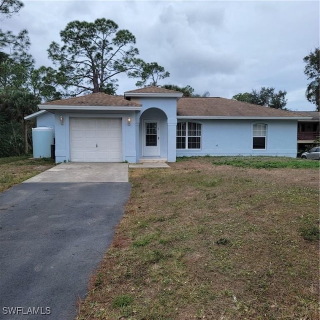 ranch-style home with a garage and a front yard