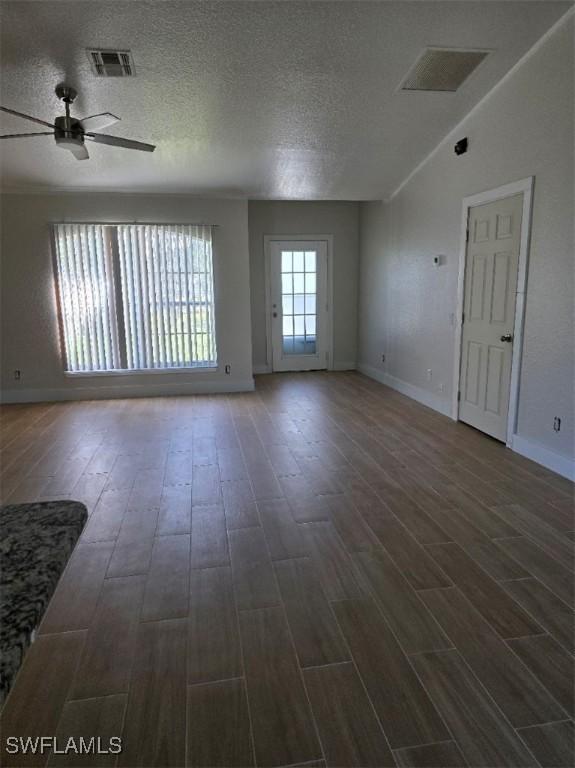 unfurnished room with dark wood-style floors, visible vents, and a textured ceiling